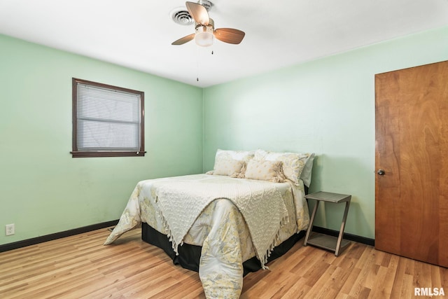 bedroom featuring visible vents, wood finished floors, baseboards, and ceiling fan