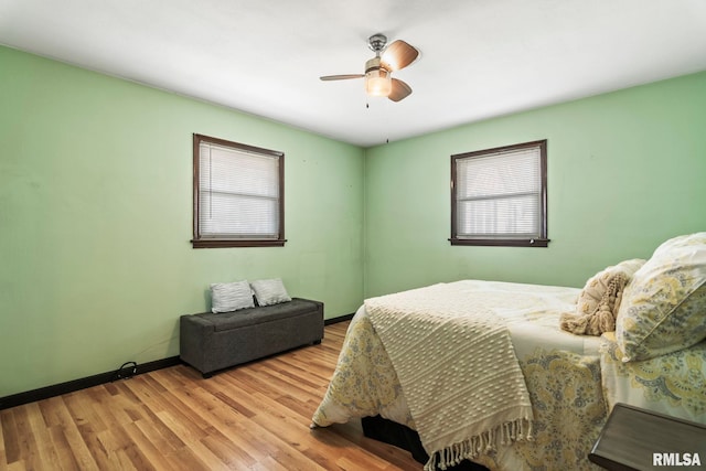 bedroom with ceiling fan, baseboards, and wood finished floors