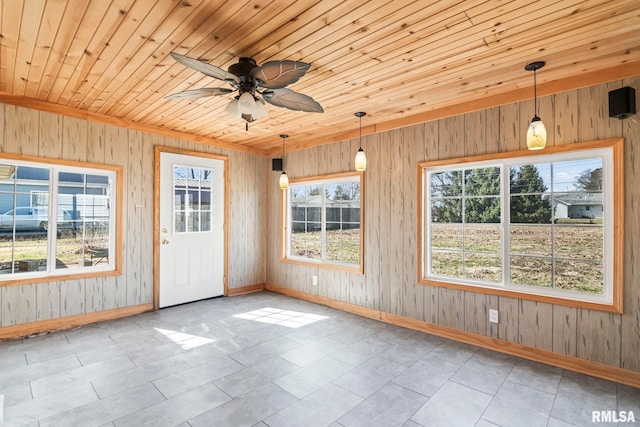 unfurnished sunroom featuring wood ceiling and a ceiling fan