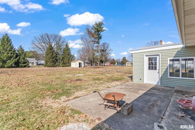 view of yard with an outdoor structure, a storage unit, and a patio area