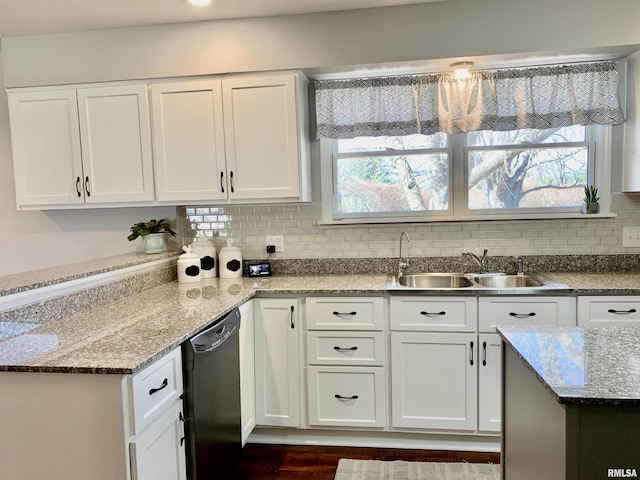 kitchen with a wealth of natural light, a sink, tasteful backsplash, white cabinetry, and dishwasher