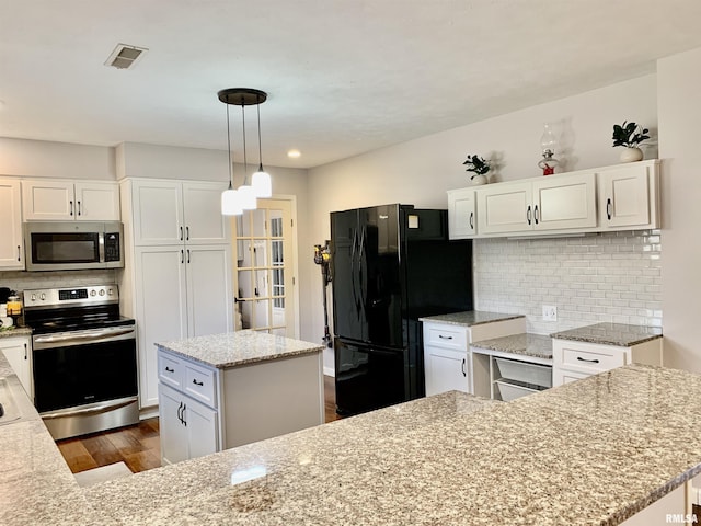 kitchen featuring a kitchen island, dark wood-style flooring, white cabinets, appliances with stainless steel finishes, and backsplash