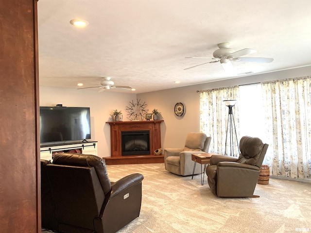 living area featuring recessed lighting, light carpet, a fireplace with raised hearth, and a ceiling fan