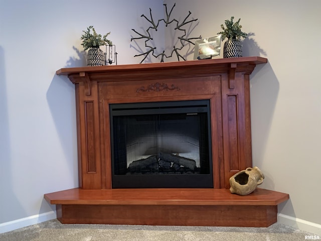 details featuring baseboards, carpet, and a fireplace