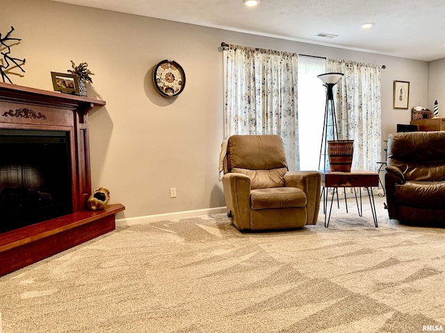 carpeted living area with visible vents, recessed lighting, a fireplace with raised hearth, and baseboards