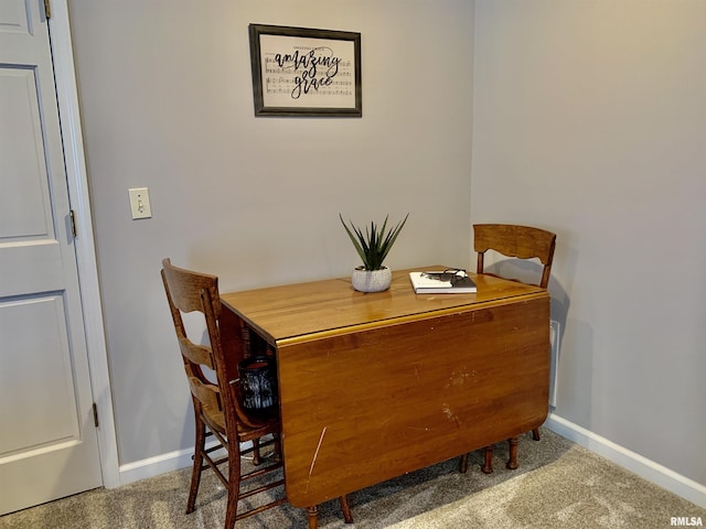 carpeted dining area with baseboards