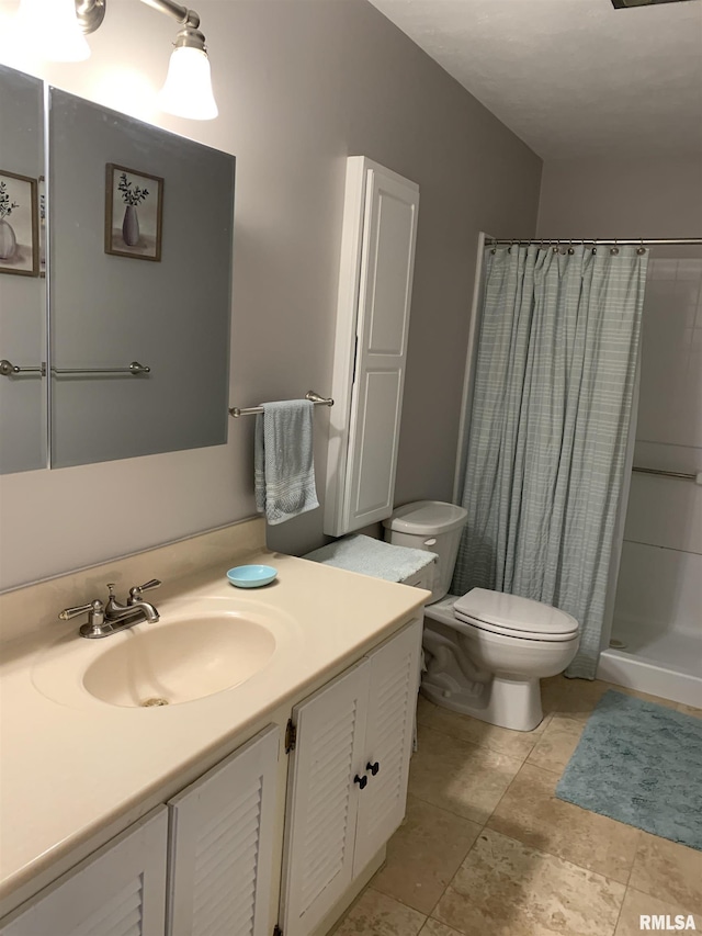 bathroom with a shower stall, toilet, and vanity