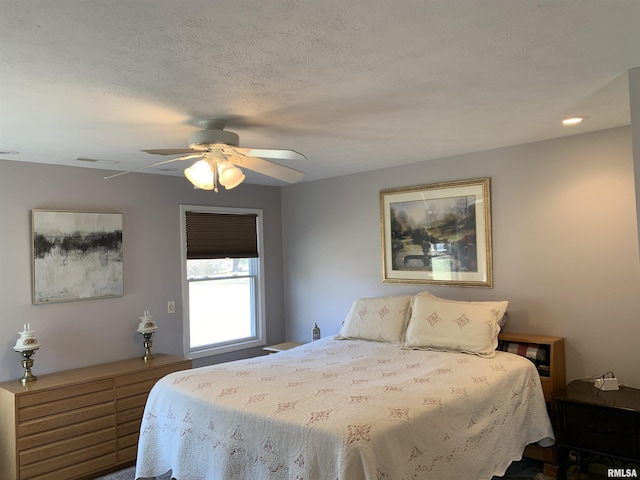 bedroom featuring visible vents, a textured ceiling, and a ceiling fan