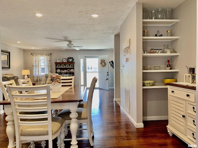 dining room featuring a ceiling fan, visible vents, baseboards, dark wood-style flooring, and a textured ceiling