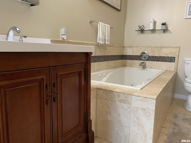 bathroom featuring tile patterned floors, toilet, a whirlpool tub, and vanity