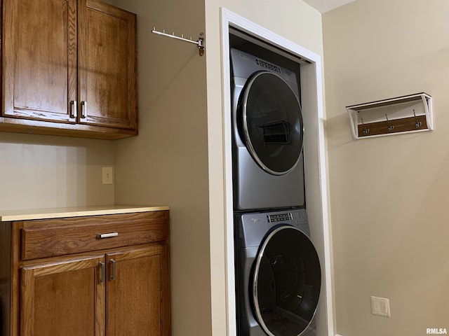 laundry area featuring cabinet space and stacked washing maching and dryer