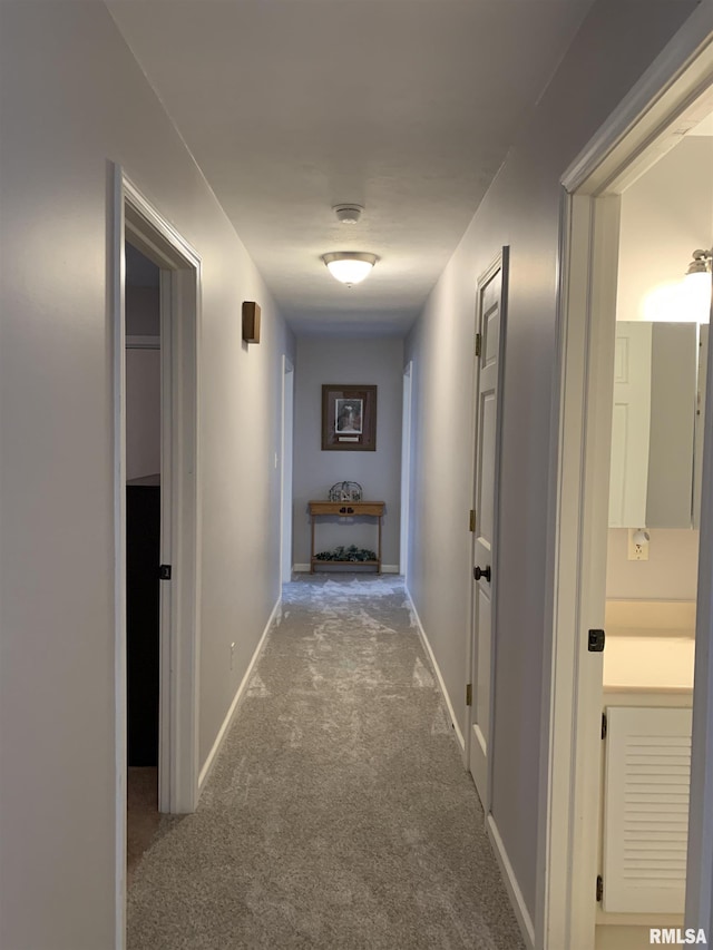 hallway with carpet flooring and baseboards