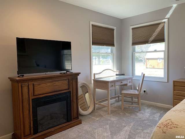 carpeted dining area featuring a glass covered fireplace and baseboards