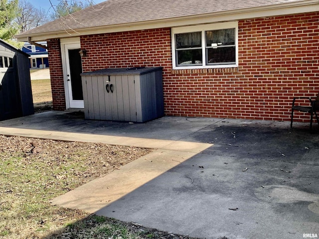 exterior space with brick siding and a shingled roof