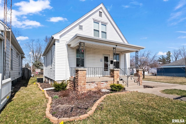 bungalow-style home featuring a porch, a front lawn, and fence