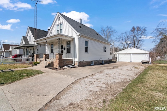 view of front facade featuring an outbuilding, fence, roof with shingles, covered porch, and a detached garage