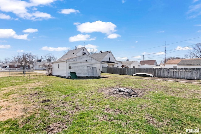 back of property featuring a lawn and fence