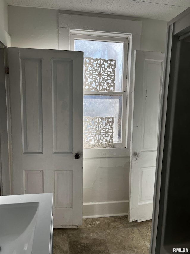 doorway to outside with baseboards and stone finish flooring