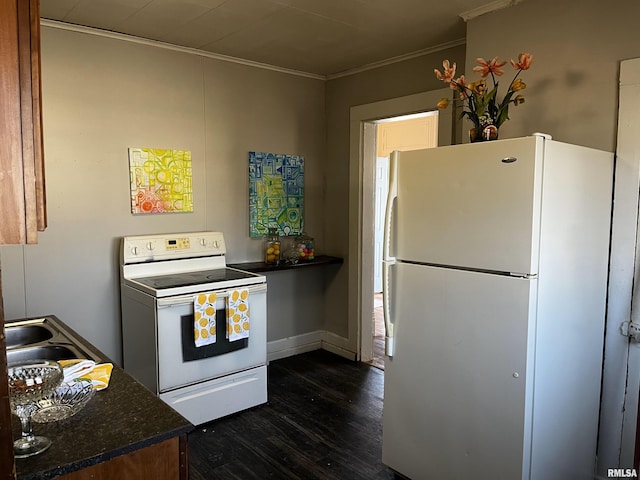 kitchen with dark countertops, dark wood-type flooring, ornamental molding, white appliances, and a sink