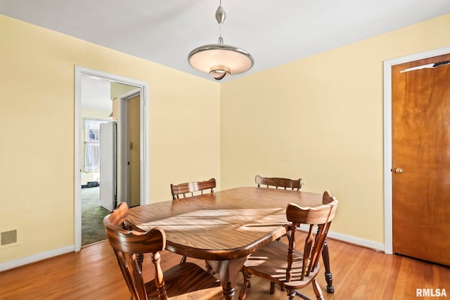 dining area with visible vents, baseboards, and light wood-type flooring