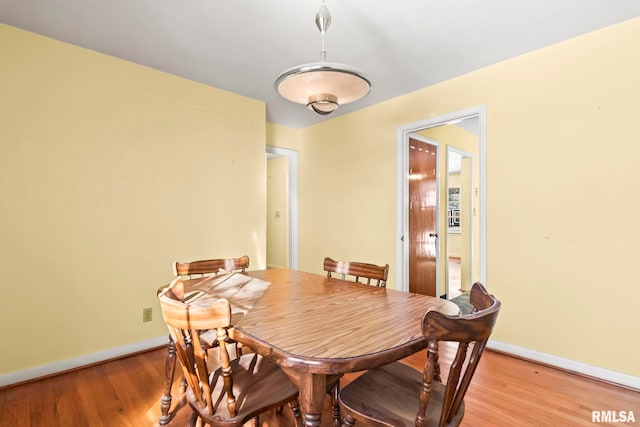 dining space featuring baseboards and light wood-style floors