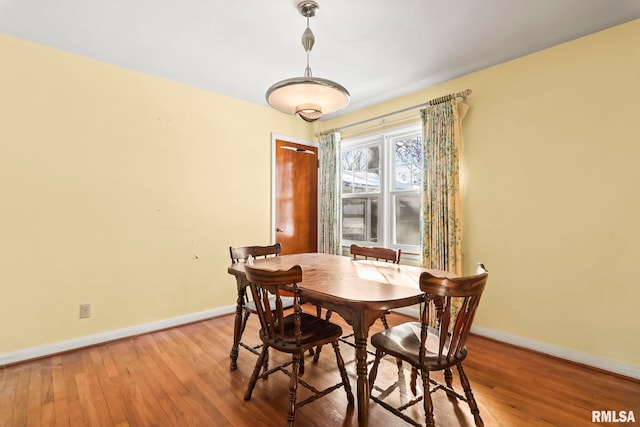 dining space featuring baseboards and wood finished floors