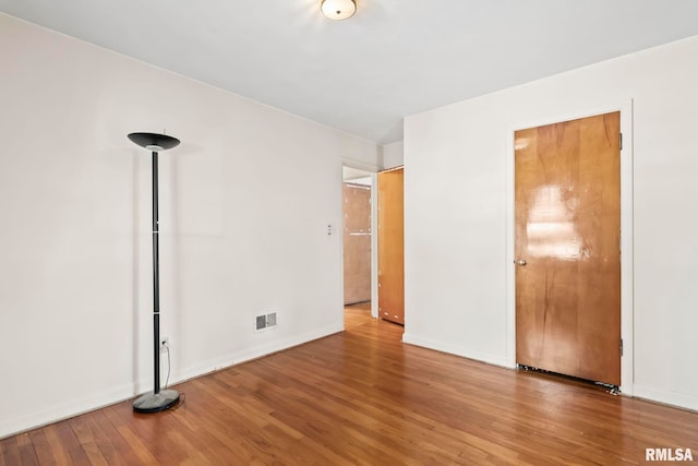 unfurnished bedroom with visible vents, baseboards, and wood finished floors