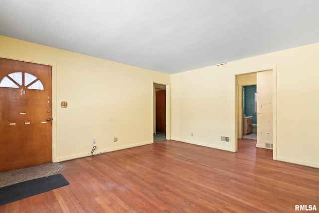 interior space with visible vents, baseboards, and wood finished floors