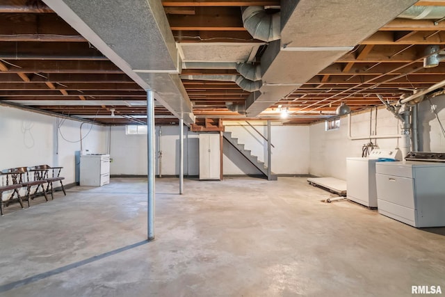 basement featuring washing machine and clothes dryer and stairs