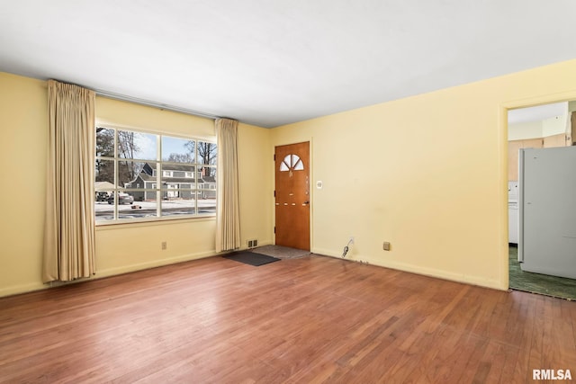 interior space featuring visible vents, baseboards, and wood finished floors