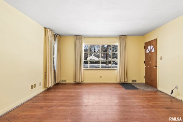 interior space with wood finished floors and visible vents