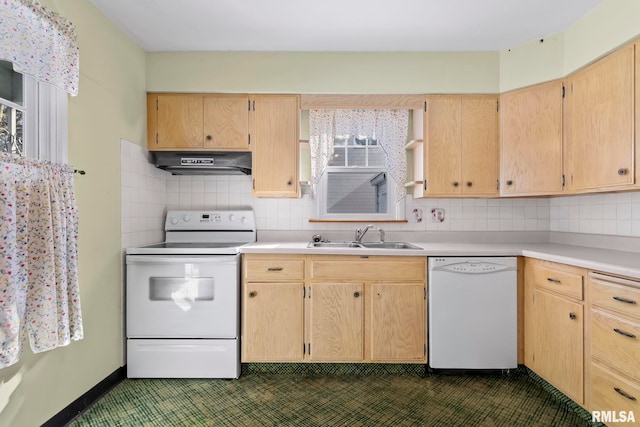 kitchen featuring decorative backsplash, white appliances, under cabinet range hood, and a sink