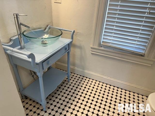 details with baseboards, vanity, and a textured wall