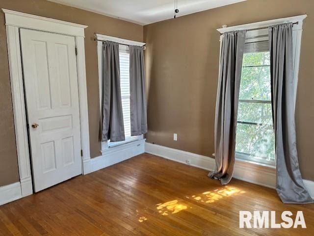 unfurnished bedroom with baseboards and wood finished floors