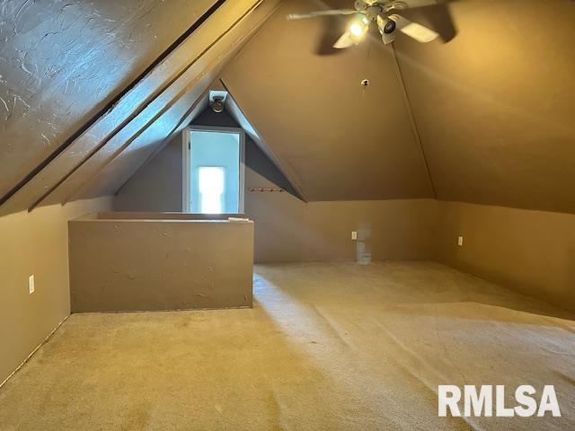 additional living space featuring vaulted ceiling, carpet flooring, and a ceiling fan