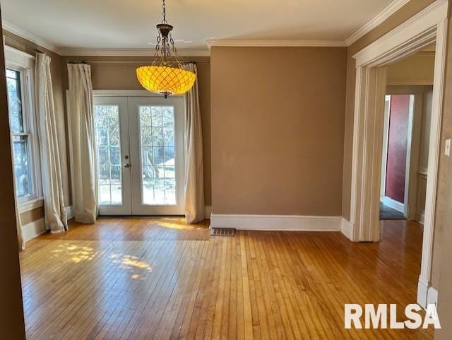 interior space featuring hardwood / wood-style floors, crown molding, french doors, and baseboards