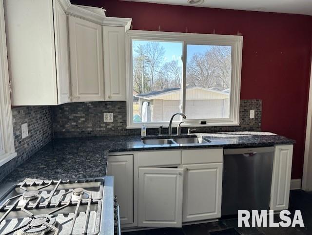 kitchen featuring a sink, tasteful backsplash, stainless steel dishwasher, and white cabinetry