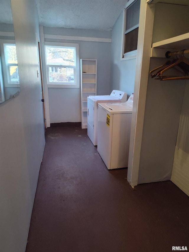 clothes washing area with laundry area, separate washer and dryer, and a textured ceiling