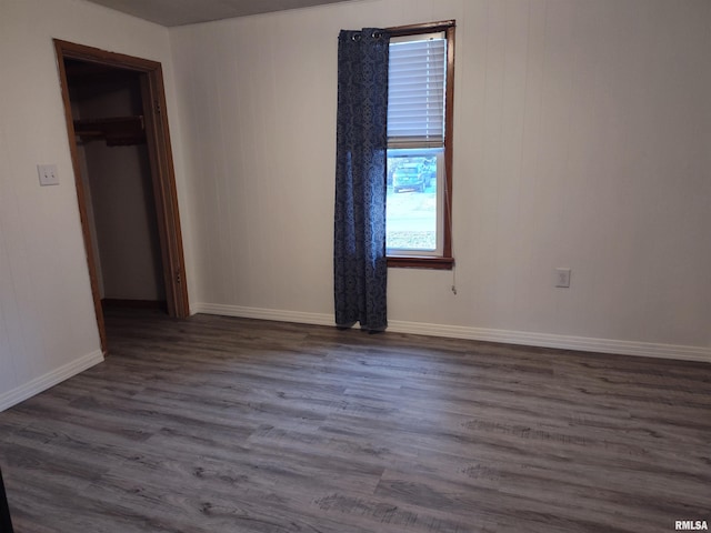 unfurnished bedroom featuring a closet, baseboards, and dark wood-type flooring