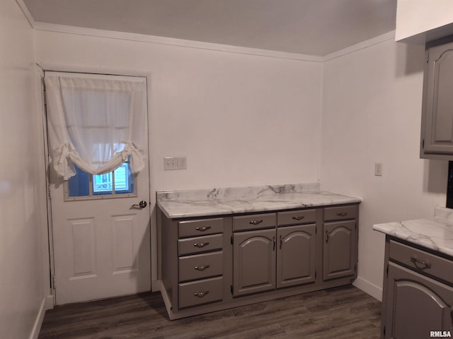 kitchen featuring baseboards, dark wood-type flooring, and gray cabinetry