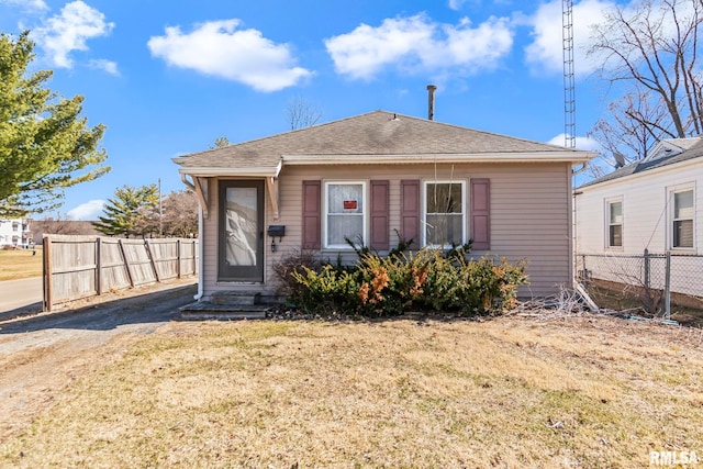 bungalow featuring roof with shingles, a front yard, and fence