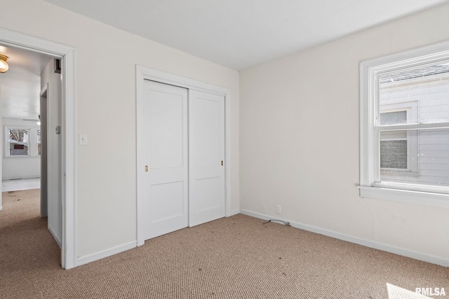 unfurnished bedroom featuring a closet, baseboards, and carpet floors