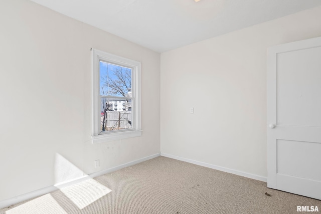 carpeted empty room with baseboards