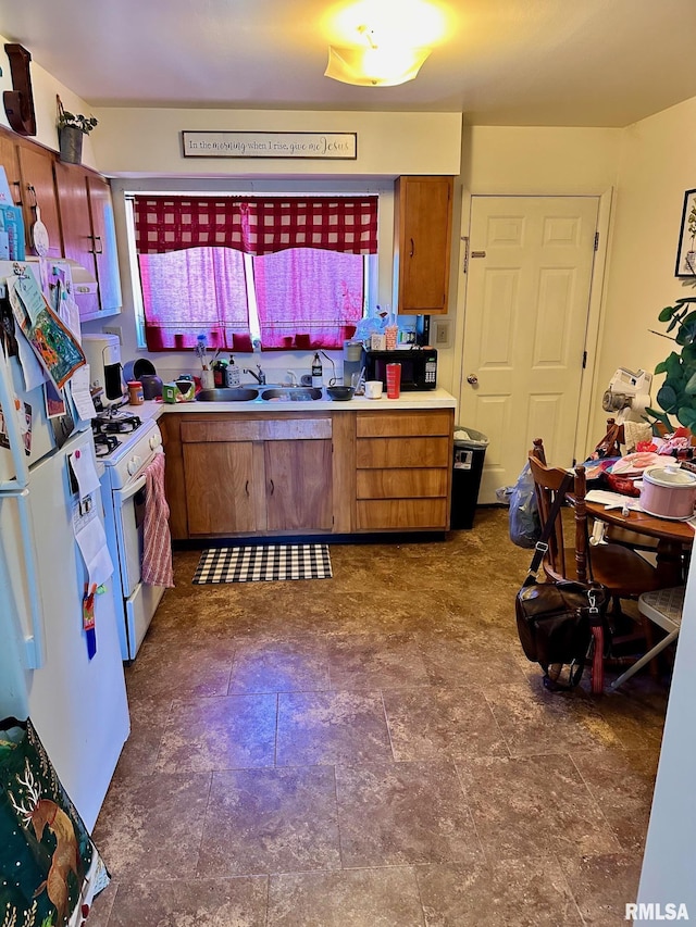 kitchen featuring white appliances, light countertops, brown cabinets, and a sink