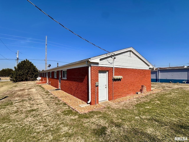 view of property exterior featuring a yard and brick siding