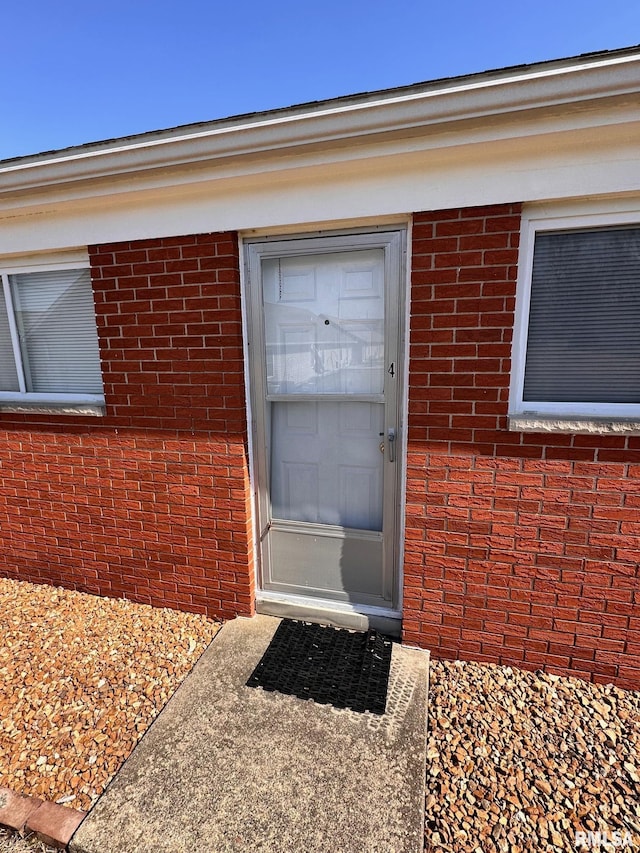 entrance to property featuring brick siding