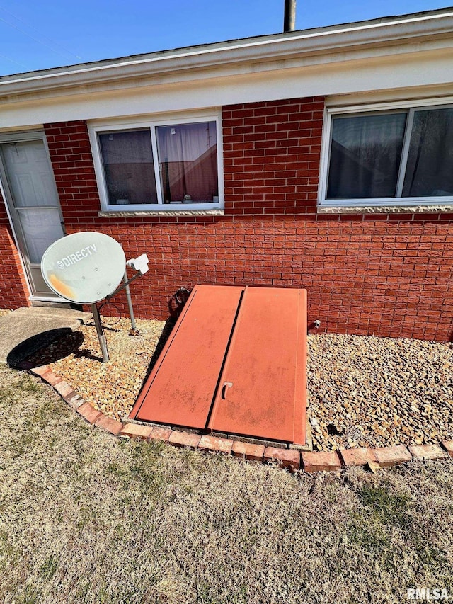 exterior space featuring brick siding and a bulkhead entry