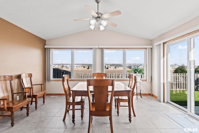 dining space featuring vaulted ceiling, light tile patterned flooring, a ceiling fan, and baseboards