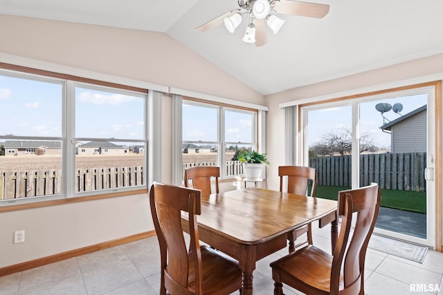 dining space featuring light tile patterned flooring, baseboards, a ceiling fan, and vaulted ceiling