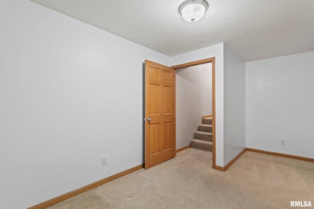 interior space featuring baseboards, stairs, and carpet